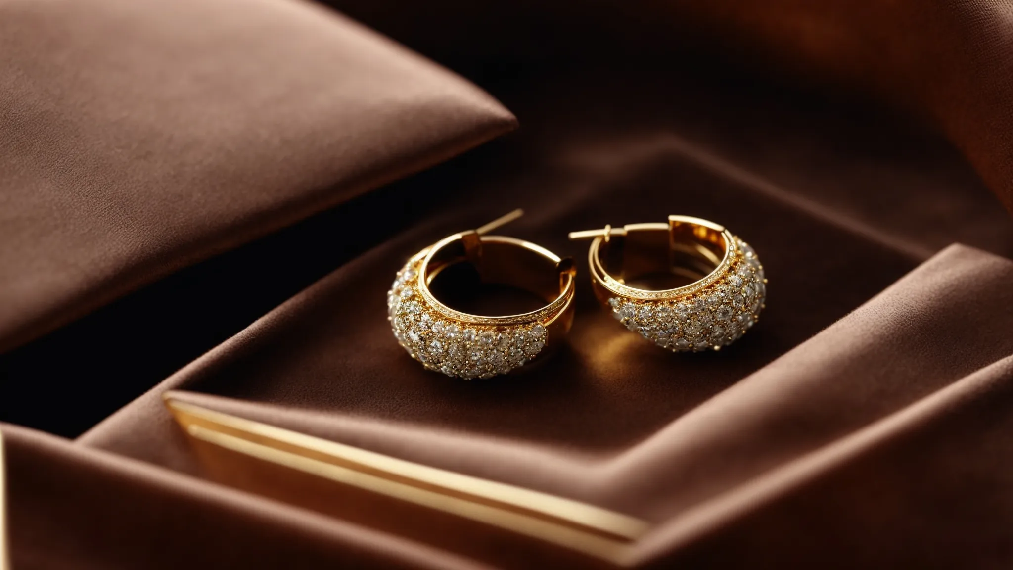 a pair of luxurious gold earrings sparkle on a velvet jewel box.