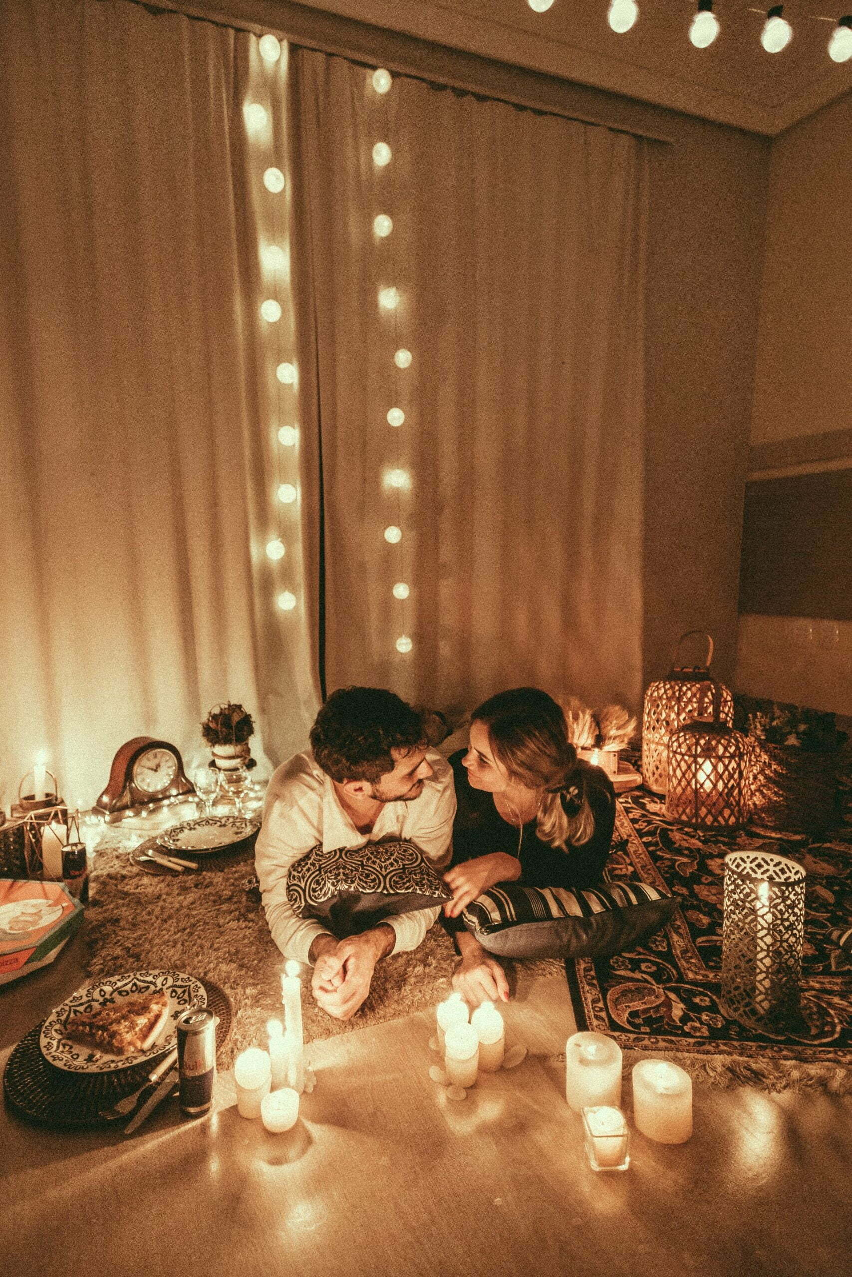a couple of people sitting at a table with candles