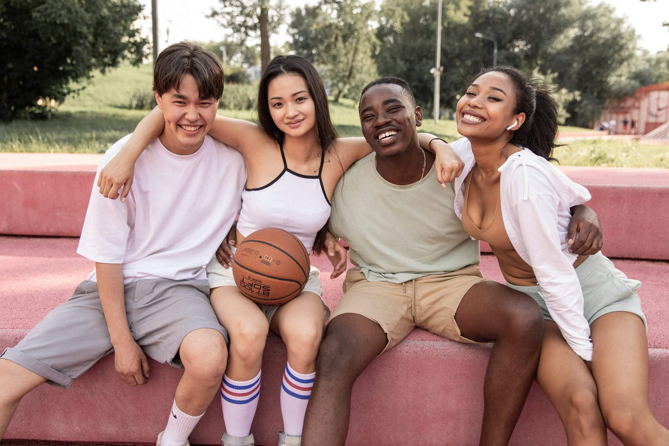 a group of people sitting on a bench posing for the camera